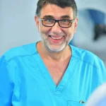 Portret al Dr. Dan Mihail Stana în costum medical, zâmbind