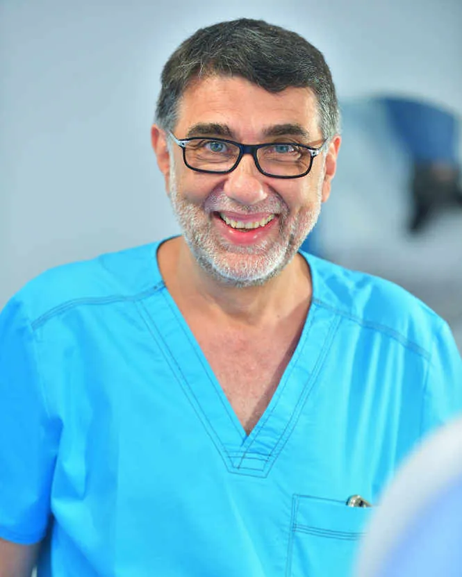 Portret al Dr. Dan Mihail Stana în costum medical, zâmbind